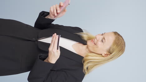 Vertical-video-of-Business-woman-shopping-on-the-phone-with-a-credit-card.
